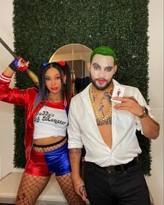 two people dressed in costumes standing next to each other and one holding a cell phone