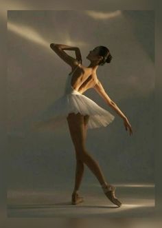 a ballerina in white is posing with her arms behind her back and head turned to the side