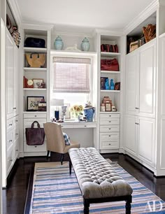 an image of a room with white cabinets and furniture in it, including a bench