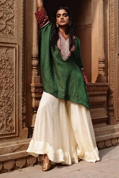 Green flowy kaftan featuring fine patterns highlighted with dori embroidery. Comes with a contrast white sharara.
Components: 2
Pattern: Embroidered
Type Of Work: Dori, Gota
Neckline: Round
Sleeve Type: Flared
Fabric: Kaftan: Silk Cotton, Pant: Organza
Color: Green
Other Details: 
Contrast border on sleeves
Panelled flared sharara
Flowy silhouette
Occasion: 
Mehendi and Haldi,Sangeet - Aza Fashions Sharara For Women, White Sharara, Flared Sharara, Green Kaftan, Dori Embroidery, Kaftan Designs, Dress Book, Gaun Fashion, Dresses Indian