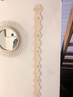 a white wall with a ruler and mirror on it