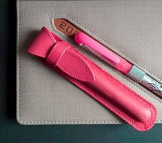 "Pink pen case for pen. Exquisite leather craftsmanship - Genuine leather pen case is crafted with high quality genuine cowhide leather attached with fine and durable stitching giving it a sleek look and a slim body. An exemplary model of artisanal craft combining the pleasant feel and the handsome look of genuine leather without sacrificing versatility and convenience Classic look - leather pen case is designed to impress with its classic and stylish look and modern color. While it is a stylish Pink Pencil Case With Pen Holders For Gift, Pink Pencil Case With Pen Holders As Gift, Pink Pencil Case With Pen Slots For Gift, Pink Pencil-shaped Pencil Case For Gift, Pink Pencil-shaped Pencil Case Gift, Red Pencil-shaped Pencil Case For Gift, Red Pencil Shaped Pencil Case Gift, Red Pencil-shaped Pencil Case Gift, Classic Pencil Case With Pen Holders As Gift