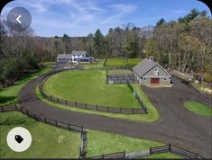 an aerial view of a horse farm and its surrounding fenced in area with trees