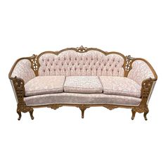 an ornately decorated couch with pink upholstered fabric and wood trimmings