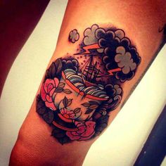 a woman's arm with a ship and roses tattoo on the left side of her leg