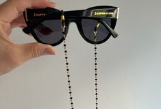 Introducing our stunning Beaded Sunglasses Chain, meticulously handcrafted with stainless steel chain, elegant black rosary, and exquisite gold beads. This one-of-a-kind creation promises to keep your glasses securely with you at all times. With three available lengths to choose from, find the perfect match for your style and always stand out from the crowd. Available exclusively at Christina Christi Store. 👉 My Sunglasses Chain Collection: https://etsy.me/2W1xaRS 👉 Express Shipping: https://e Elegant Handmade Metal Glasses Chains, Black Glass Glasses Chain For Parties, Trendy Black Metal Glasses Chains, Trendy Black Glasses Chains As Fashion Accessory, Trendy Black Glass Jewelry, Elegant Glasses Chains With Lobster Clasp, Black Metal Glasses Chain With Adjustable Feature, Black Metal Glasses Chains With Adjustable Chain, Black Metal Glasses Chain With Adjustable Length