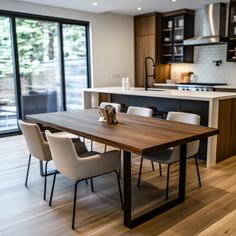 a dining room table and chairs in front of an open kitchen with sliding glass doors