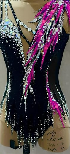 a mannequin wearing a black and pink dress with sequins on it