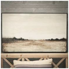 a painting hanging on the wall above a bed in a room with wood paneling