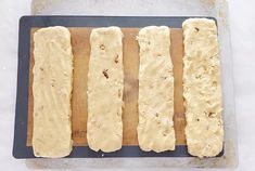 four pieces of bread sitting on top of a wooden cutting board next to a knife