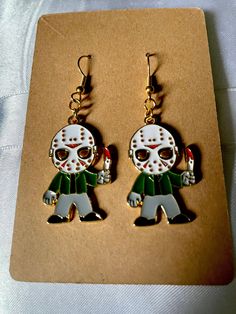 These handmade Jason earrings are perfect for Halloween, horror movie night, or just wearing to look great! Fun Halloween Earrings For Gifts, Fun Halloween Earrings Gift, Fun Halloween Gift Earrings, Halloween Novelty Drop Earrings Jewelry, Halloween Novelty Drop Earrings, Novelty Halloween Pierced Earrings, Novelty Pierced Earrings For Halloween, Novelty Drop Earrings For Halloween, Gold Novelty Earrings For Halloween