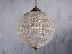 a chandelier hanging from the ceiling in a room with concrete walls and flooring