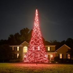 a lighted christmas tree in front of a house