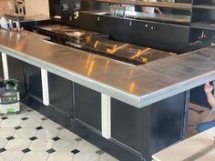 a man working in a commercial kitchen with stainless steel counter tops