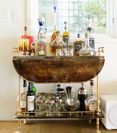 a bar cart filled with liquor bottles and glasses