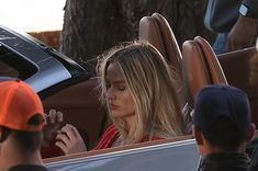 a woman sitting in the driver's seat of a car with her eyes closed