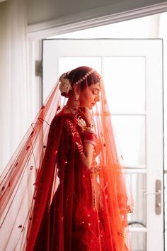 a woman in a red wedding dress and veil