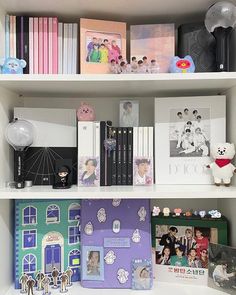 a book shelf filled with lots of books next to stuffed animals and other items on top of it