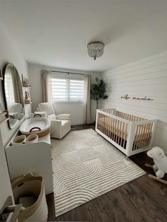 a baby's room with white walls and wood floors