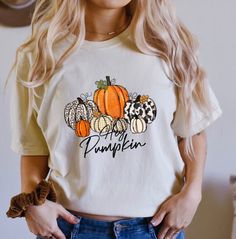 Comfort Colors® Pumpkin Season t-shirt, Gift For Halloween, Halloween Shirt, Cute fall T-shirt, Spooky Season, Halloween Pumpkin Shirt A Comfort Colors shirt is a type of casual t-shirt that is known for its softness, relaxed fit, and muted color palette. Typically made from 100% cotton, these shirts have a vintage feel and are often favored for their comfortable, worn-in look. This classic unisex jersey short sleeve and long sleeve tees fits like a well-loved favorite. Soft cotton and quality print make users fall in love with it over and over again. These t-shirts have-ribbed knit collars to bolster shaping. The shoulders have taping for better fit over time. Dual side seams hold the garment's shape for longer.  *6.1 oz./yd² (US), 10 oz/L yd (CA), 100% ring spun cotton, 30 singles *Garme Spooky Cotton Top For Fall, Spooky Cotton Tops For Fall, White Screen Print Shirt For Fall, Spooky Short Sleeve Tops For Fall, White Graphic Tee For Fall, White Custom Print Shirt For Fall, Orange Screen Print Top For Fall, Fall Crew Neck Tops With Custom Print, Fall Custom Print Short Sleeve Tops