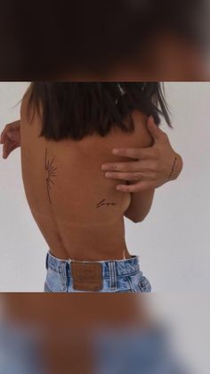 the back of a woman's body with tattoos on it