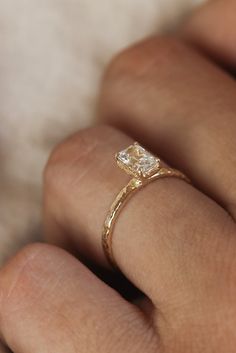 a woman's hand with a diamond ring on it