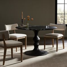 a dining table with four chairs around it in front of a window and vases on the table