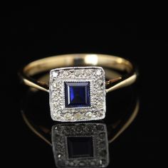 An antique Edwardian sapphire and diamond ring, crafted in 18ct gold and topped with platinum. The square sapphire of approx 0.4ct, and is surrounded by 16 eight cut diamonds weighing an approx total of 0.16ct. Head dimensions: 9.20mm x 9.15mm The stones in the ring have been checked to make sure that they are all secure, and the ring has had a polish. It is currently a UK size O, US 7, but can be resized. The ring has been professionally tested as 18ct gold and high grade platinum (980/1000) Gr Rectangular Sapphire Anniversary Ring, Sapphire Ring With Square Diamond Cut, Rectangular Brilliant Cut Sapphire Ring, Rectangular Sapphire Ring With Brilliant Cut, Rectangular Sapphire Rings With Brilliant Cut, Square Cut Sapphire Ring With Diamond Detail, Gold Sapphire Asscher-cut Ring, Rectangular Sapphire Diamond Ring, Gold Asscher Cut Sapphire Rings