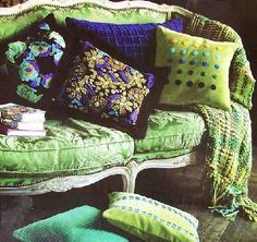 a green couch with many pillows on it