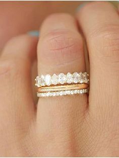 a woman's hand with a gold ring and diamond band on her left hand