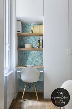 a white chair sitting in front of a book shelf next to a wall with books on it