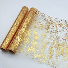 two rolled up gold glitter paper sitting on top of each other