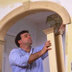 a man is working on a light fixture