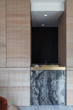 a modern kitchen with marble counter tops and wooden cabinets in an apartment space that has been designed for entertaining