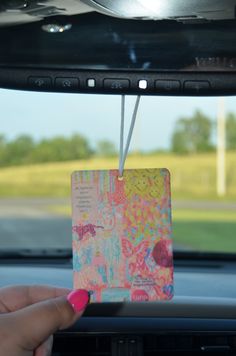 someone is holding up a card in the back seat of a car that has been decorated with colorful designs