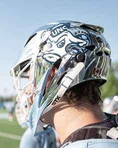 a man wearing a lacrosse helmet on top of a field