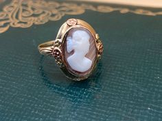 This is a darling carved cameo ring, with floral details. This ring shows some vintage wear, which is just fine with us! We love this right facing cameo, set on a light brown stone with diagonal striations.  Details: Metal Purity -10k yellow/white (marked & professionally acid tested) Ring size - 8 US - If you need a different size, just message us. Weight - 4.6 g Height off finger - 6.35 mm Cameo - 14 mm x 9 mm If this isn't your size, you are welcome to have it sized on your own, OR we can have it sized for a modest cost (just message us with your desired size PRIOR to purchasing and we will make it happen!). Layaway available via PayPal invoicing. Please see shop policies for more details. About our vintage jewelry: Our jewelry is 100% crafted with vintage materials, as we try to retain Vintage 14k Gold Cameo Rings, Victorian Cameo Rings For Anniversary, Antique Cameo Signet Ring For Weddings, Antique Cameo Ring In Yellow Gold, Antique Yellow Gold Cameo Ring, Antique Cameo Yellow Gold Ring, Vintage Yellow Gold Cameo Rings, Antique Cameo Ring Collectible, Vintage Cameo Rings For Wedding