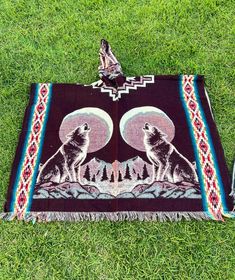 Introducing our beautifully handcrafted poncho, featuring a stunning and unique design of a wolf howling at the moon. This exquisite piece is double-sided and hooded, making it both a statement of style and a functional choice for outdoor activities. Whether you're camping under the stars, attending a music festival, or simply looking for extra warmth on a cold day, this poncho offers the perfect aesthetic for every adventure. Each poncho is handcrafted with precision and care, ensuring a unique and authentic product that is unlike anything else. This one-size-fits-most poncho measures 48 inches in width and 38 inches in length, including the fringes. Expertly crafted from a blend of 80% Alpaca and 20% Acrylic, it offers unparalleled warmth and durability. The detailed craftsmanship and do Handmade Bohemian Cape One Size, Bohemian Handmade Cape Poncho, Bohemian Handmade Poncho Cape, Handmade One Size Bohemian Cape, Handmade Bohemian One-size Cape, Handmade Bohemian Poncho Cape, Handmade Brown Bohemian Poncho, Bohemian Handmade Cape Shawl, Handmade Bohemian Cape Shawl