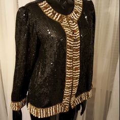 Beautiful 100% Silk Black Sequin Jacket From India. Embroidered With Pearls In The Front, Cuffs, And Front Neckline. Polyester Shell. Never Worn. Gold Embroidery As Well With Red And Blue Stones Around The Pearls. Chest Is 21 In Wide. Length From Top Shoulder To Bottom Is 23 In. Sleeve Length Is 21 In. I'm A Fast Shipping Seller - I Accept Reasonable Offers. Send One My Way - You Rock! Thanks For Stopping By Black Embellished Long Sleeve Outerwear, Vintage Embellished Festive Outerwear, Festive Embellished Vintage Outerwear, Festive Vintage Embellished Outerwear, Vintage Black Embellished Outerwear, Vintage Embellished Outerwear For Festive Occasions, Embroidered Long Sleeve Evening Blazer, Vintage Fitted Outerwear For Festive Occasions, Long Sleeve Embroidered Evening Blazer