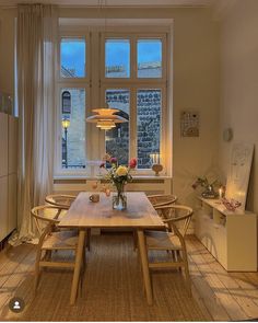 a dining room table and chairs in front of a window