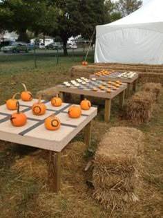 several tables with pumpkins and cupcakes on them sitting in hay bales