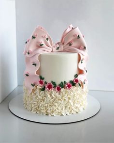 a white cake with pink bows and flowers on it