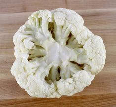 a piece of cauliflower sitting on top of a wooden table