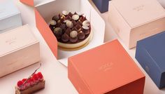 several boxes with different types of desserts in them on a white surface, one has a piece of cake and the other is empty