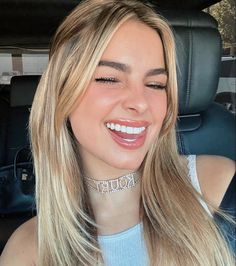 a woman sitting in the back seat of a car with her eyes closed and smiling