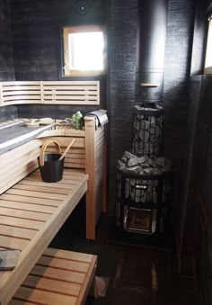 there is a sauna in the room with two benches and a trash can on the floor