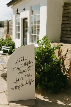 a sign that is on the ground in front of a house