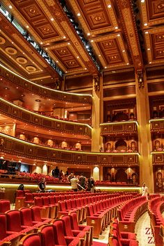 an auditorium filled with red seats and people