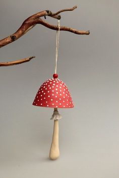 a red and white mushroom lamp hanging from a tree branch