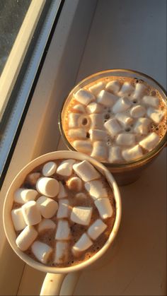 two cups filled with hot chocolate and marshmallows